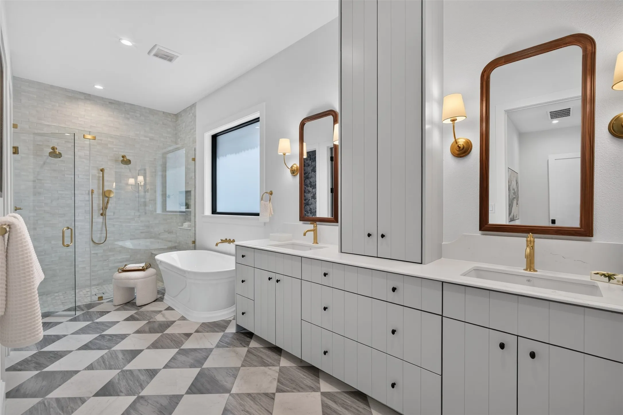 Expansive bathroom featuring a standalone soaking tub and an oversized glass-enclosed shower with gold-tone fixtures