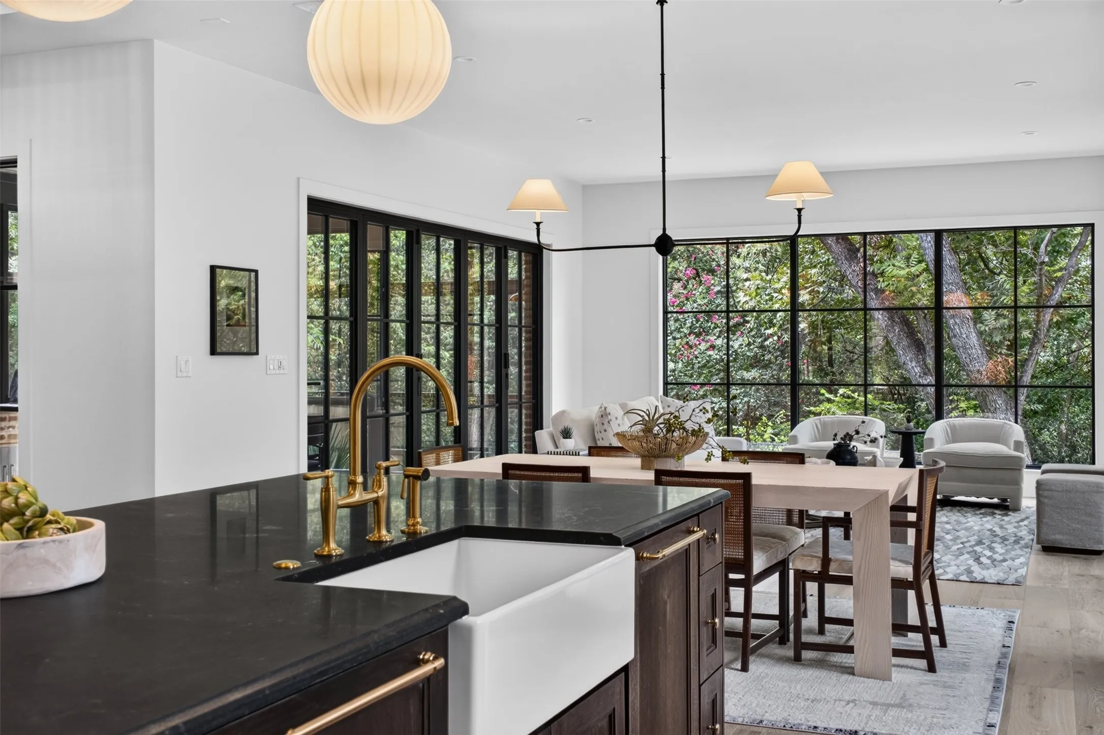 Gourmet kitchen island with a farmhouse sink, brass faucet, and dark countertops