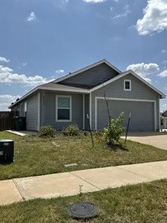 Single-story residence with gray siding, attached front-facing garage, and a concrete driveway