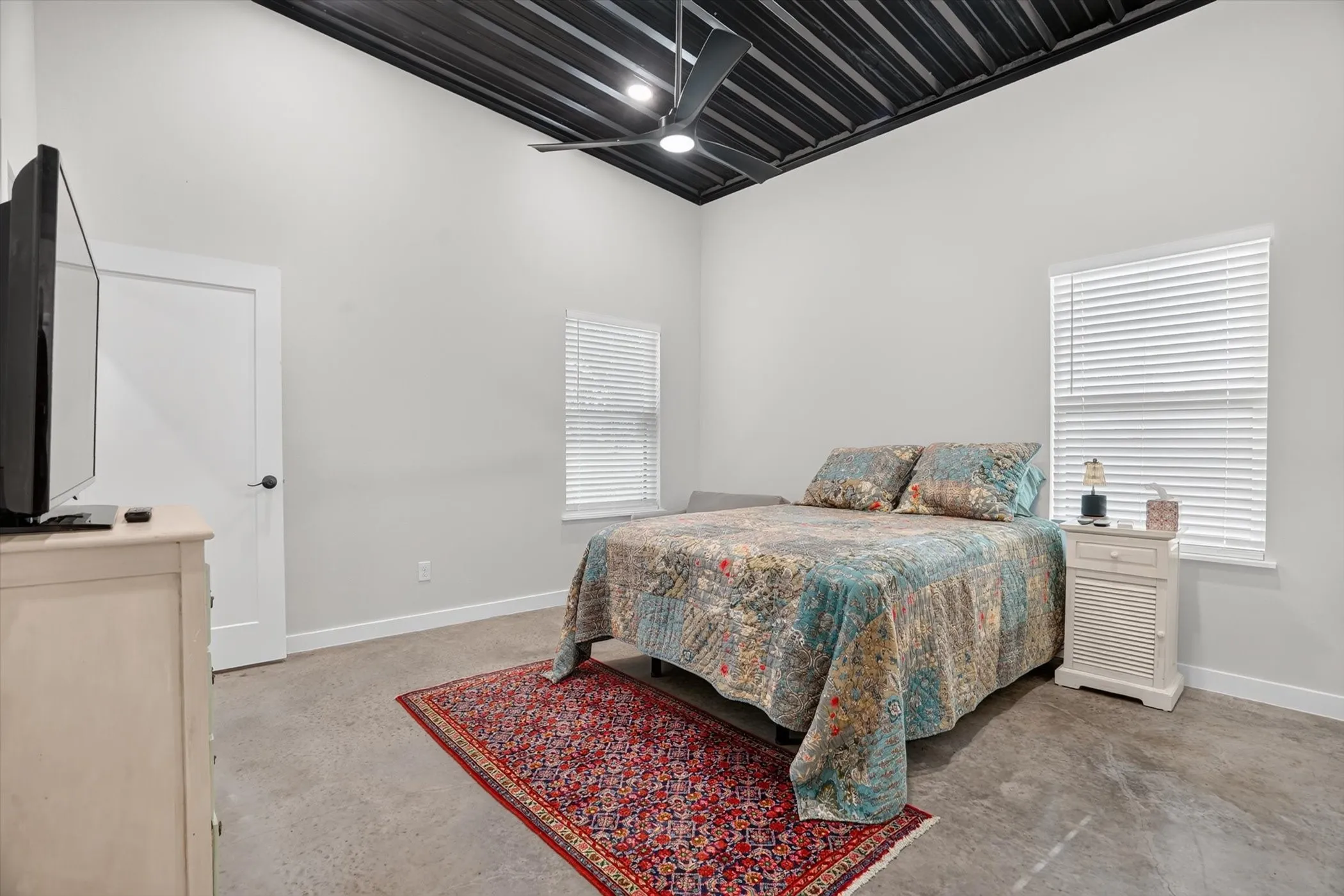 Vaulted ceiling with exposed black ceiling joists and a ceiling fan