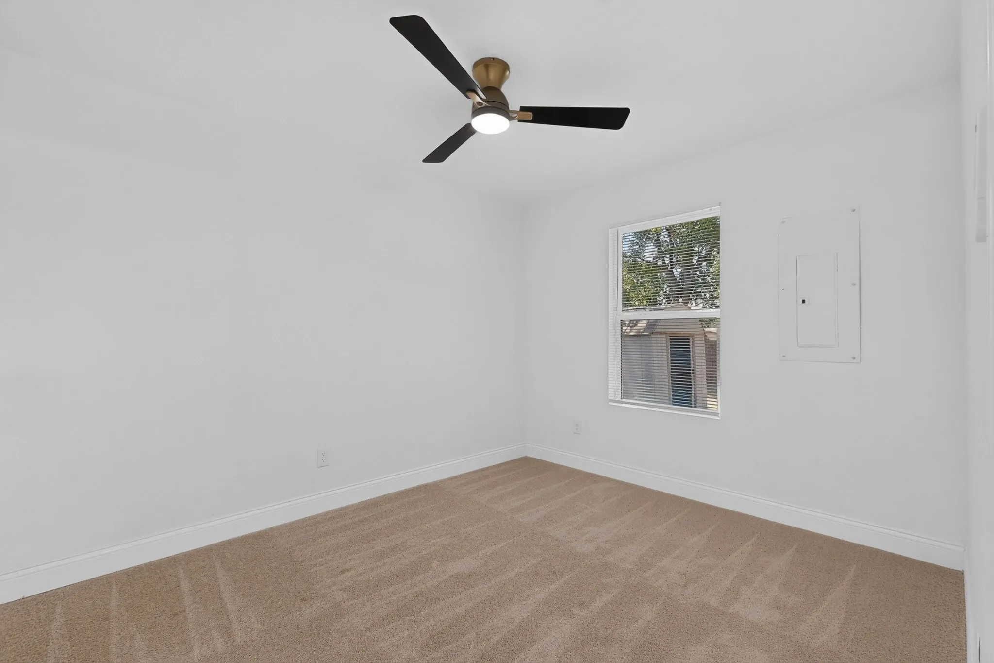 Bedroom 3 with neutral-toned carpet flooring complements crisp white walls in this room, featuring a window with exterior views