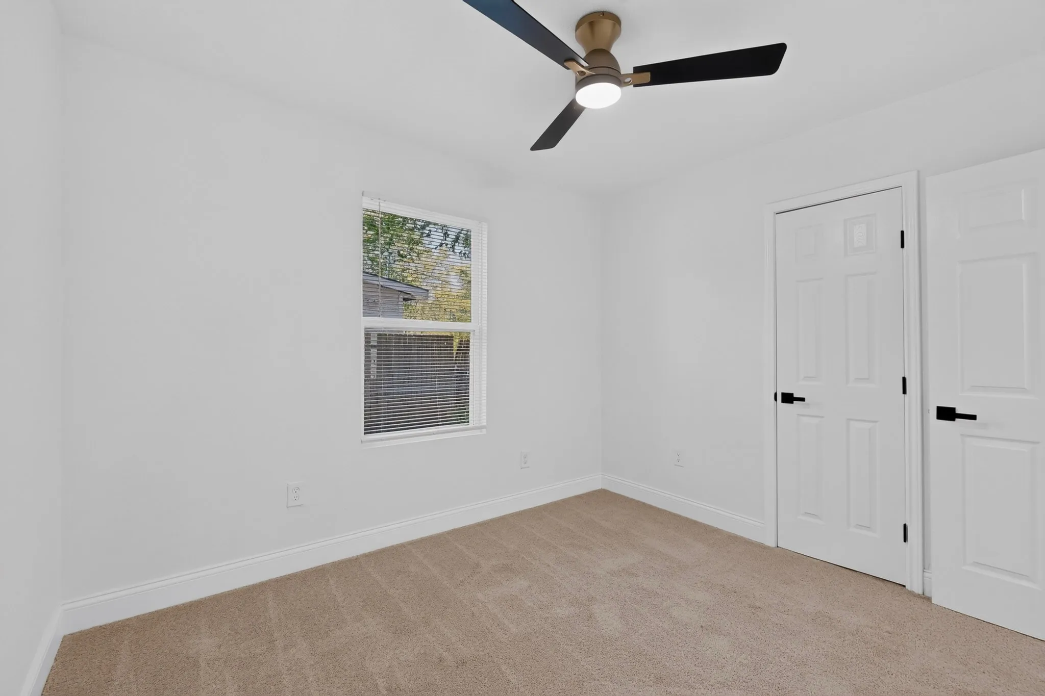 Bedroom 2 featuring a neutral carpet, white walls, and a modern ceiling fan with integrated lighting