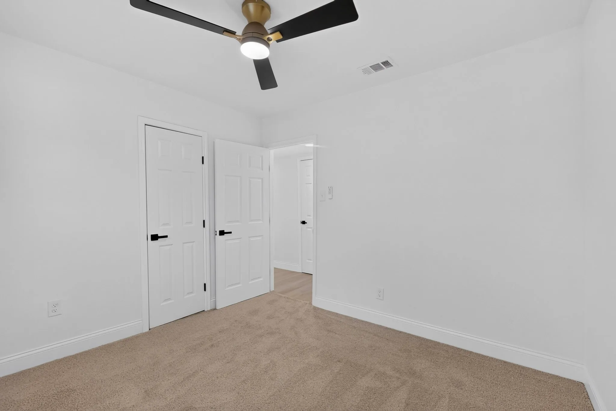Bedroom 2 featuring a neutral carpet, white walls, and a modern ceiling fan with integrated lighting