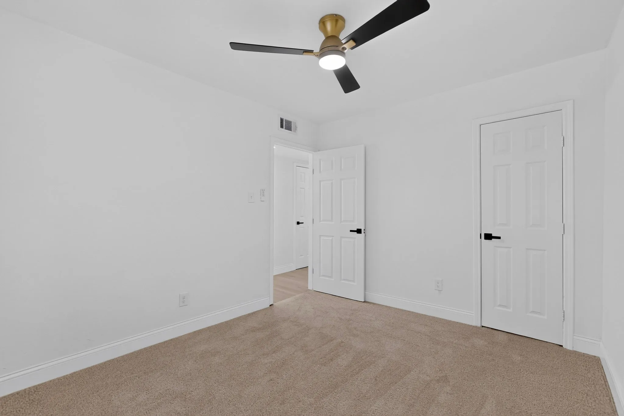 Bedroom 3 with neutral-toned carpeting extends throughout this room featuring white walls and white trim