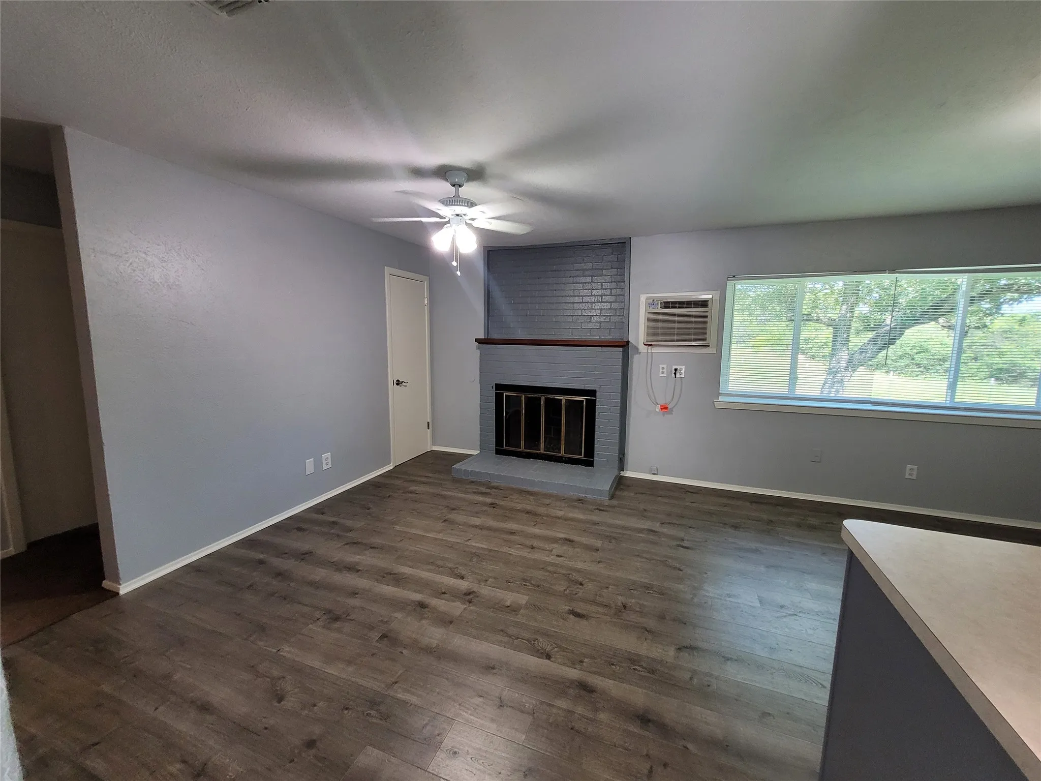 Open family room with walk in closet and wood burning fireplace.