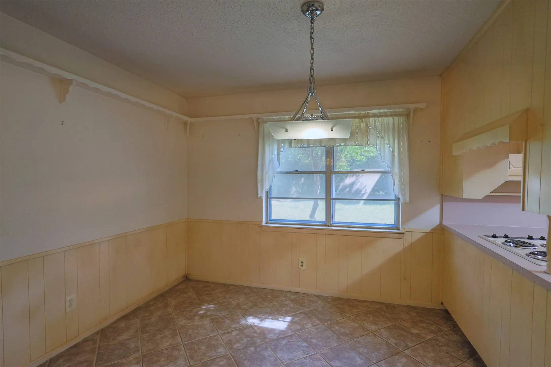 Kitchen space with tile flooring, a window, and built-in cabinetry