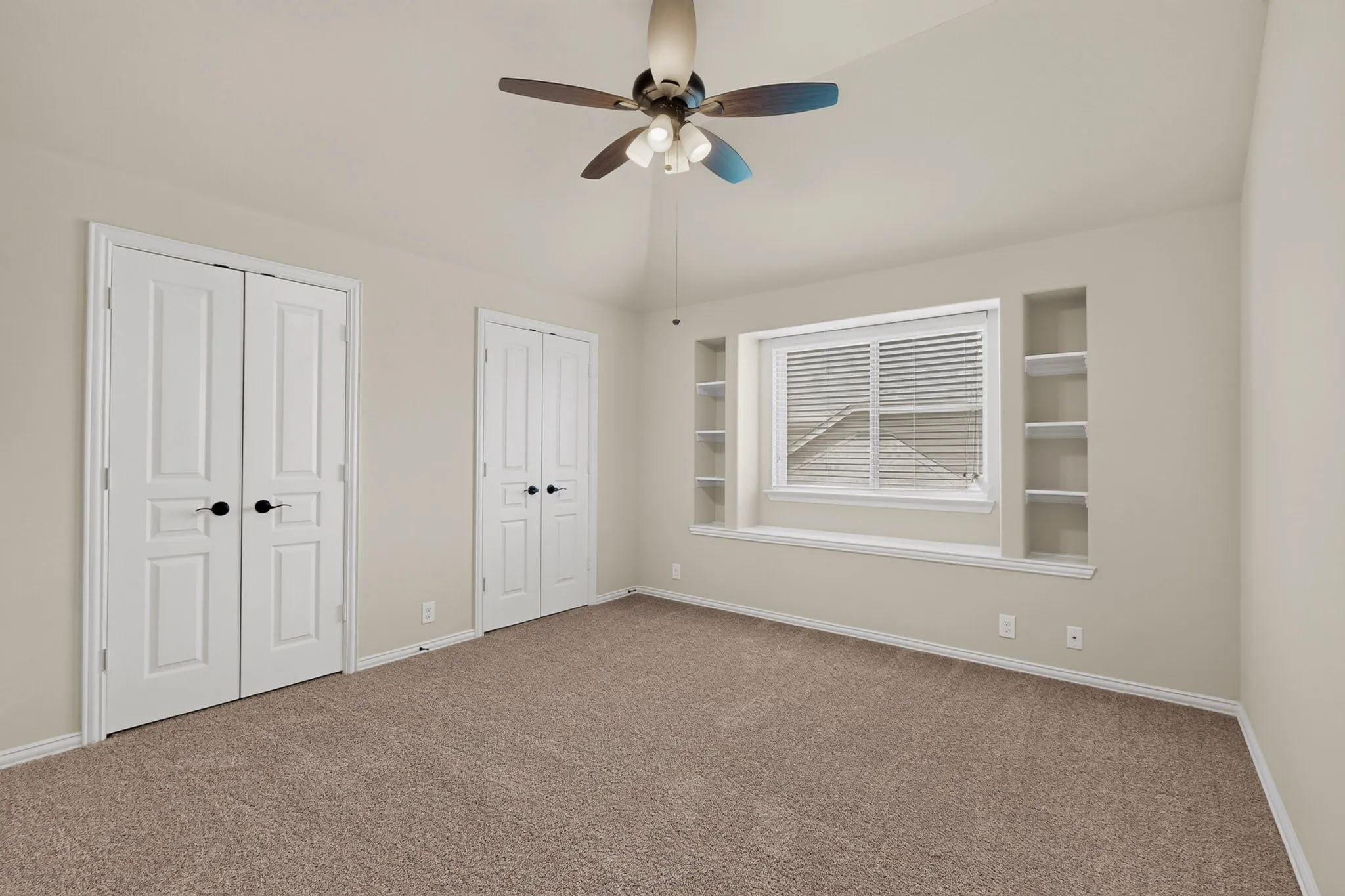 Carpeted room featuring a vaulted ceiling and a ceiling fan