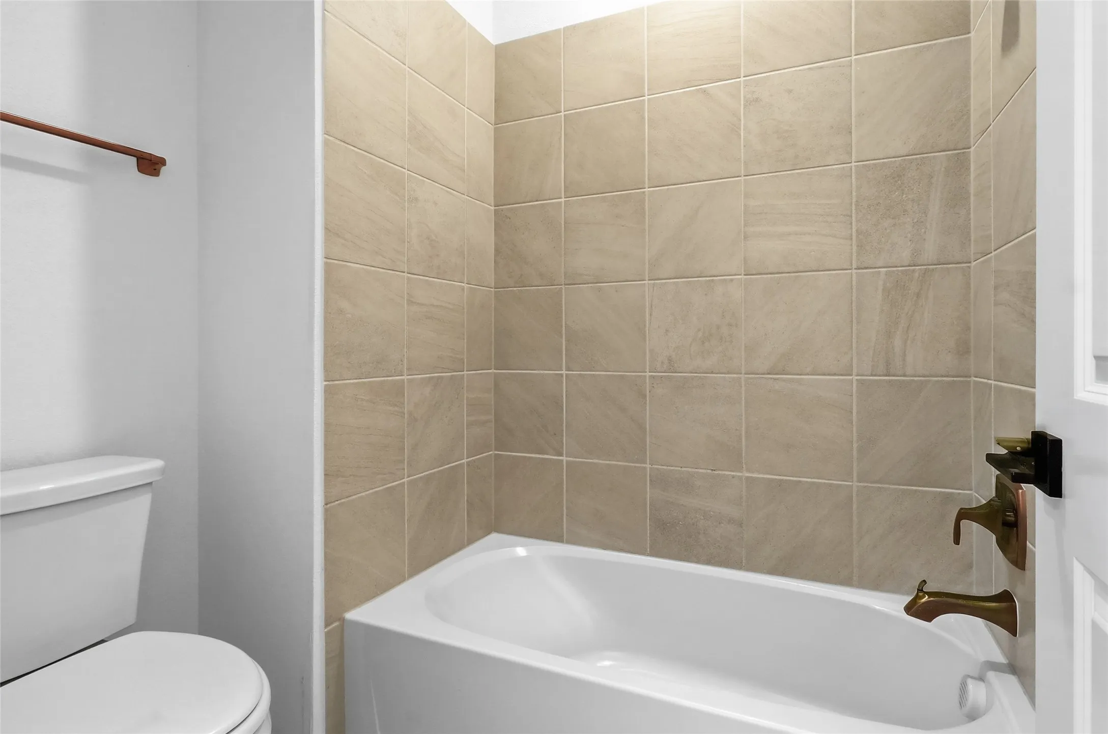 Bathroom featuring a white bathtub with a tiled surround