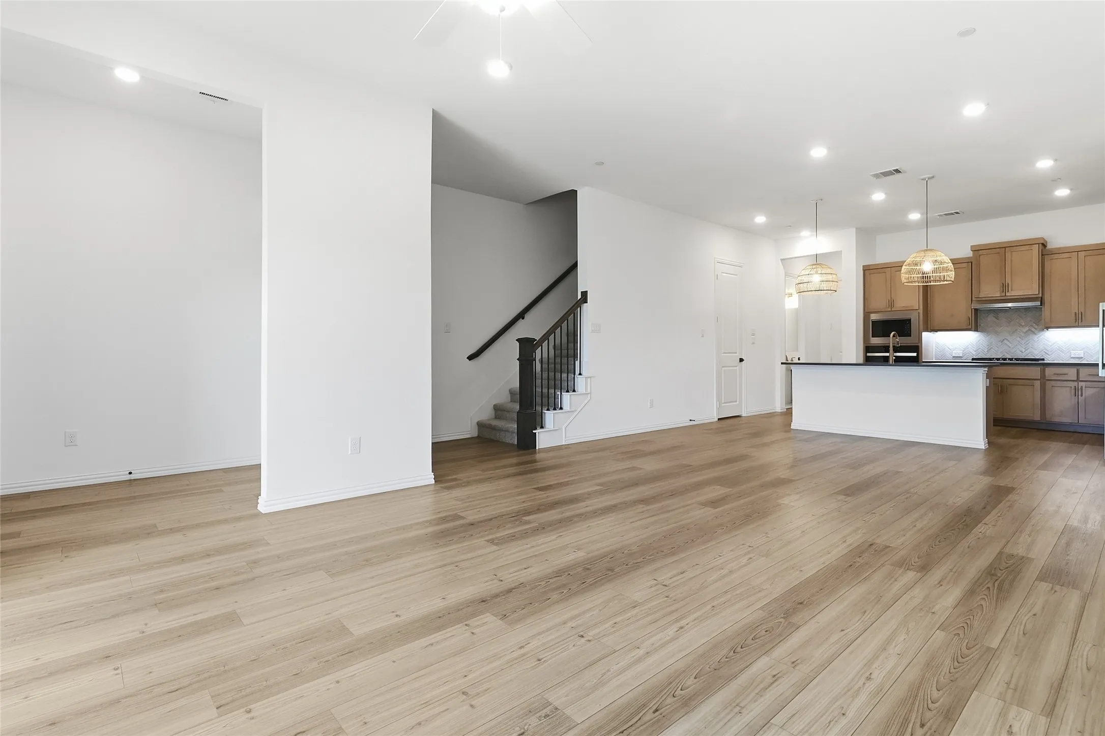 Open-concept main living area with wood-finish flooring