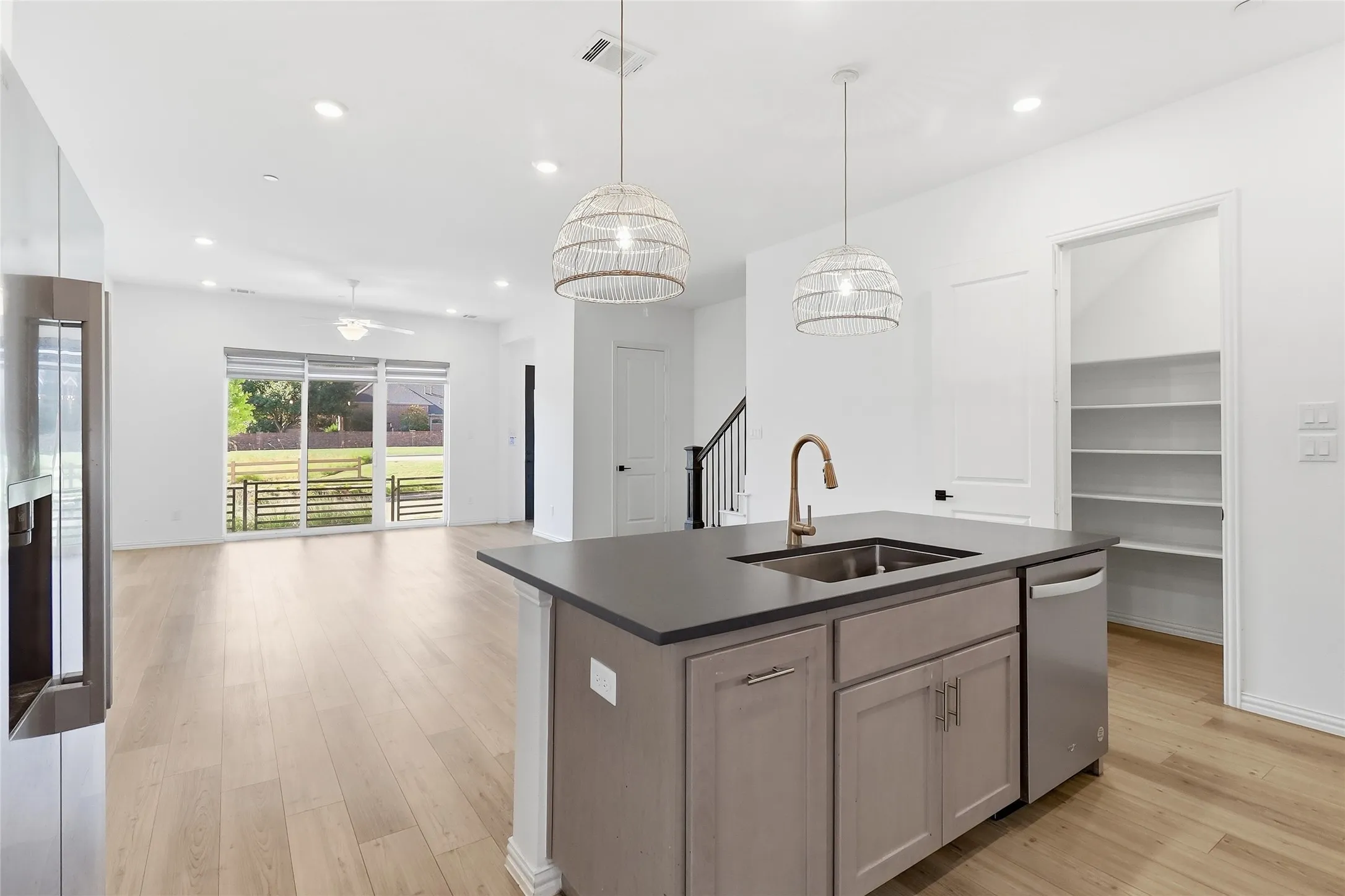 Modern kitchen island with integrated sink, brass-finish faucet, and stainless steel dishwasher