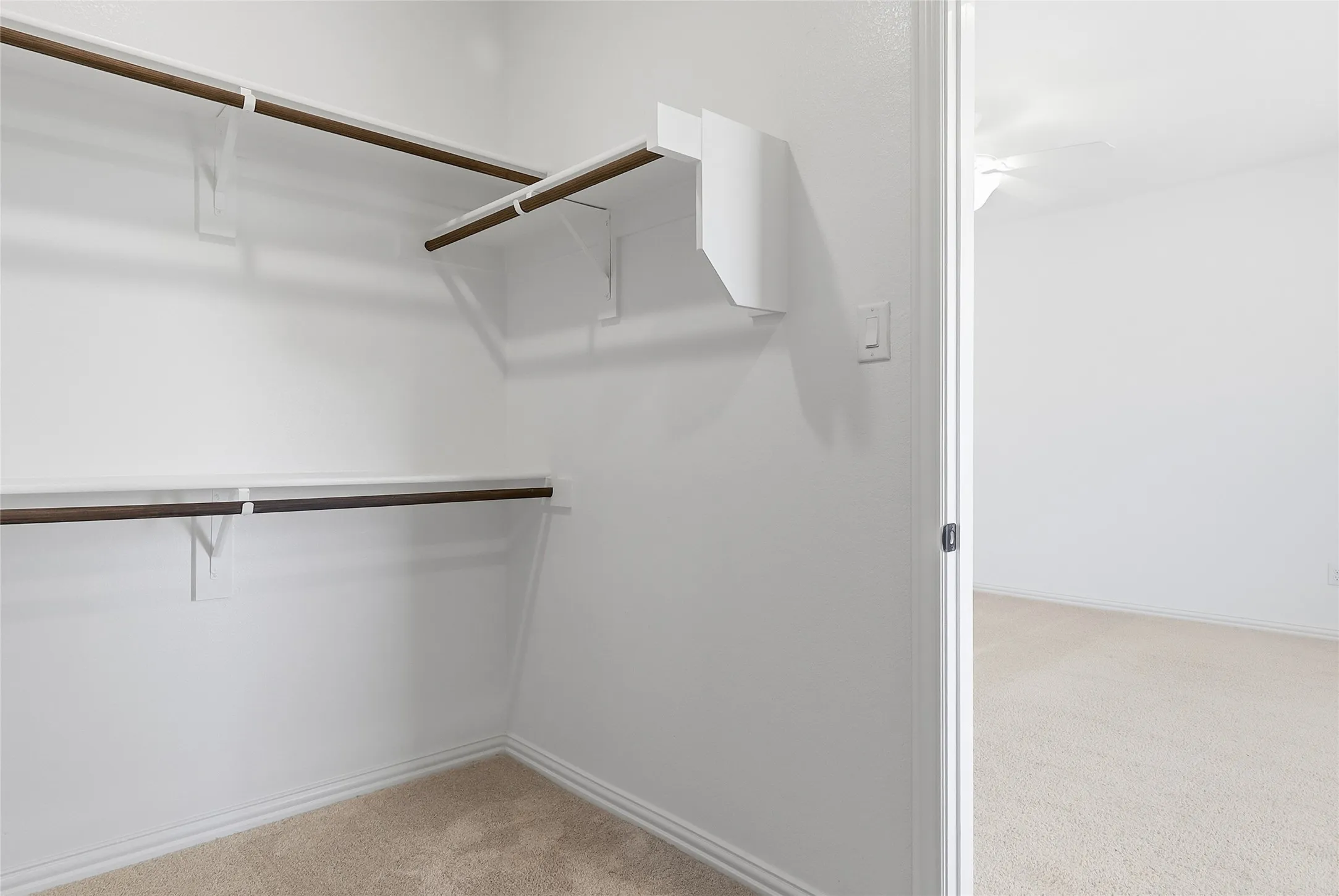 Walk-in closet featuring built-in shelving and hanging rods