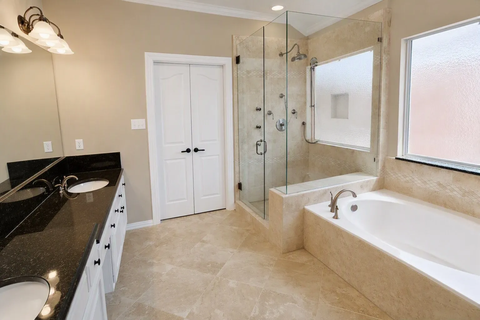 Dual vanity with dark granite countertop, full-height mirror, and white cabinetry