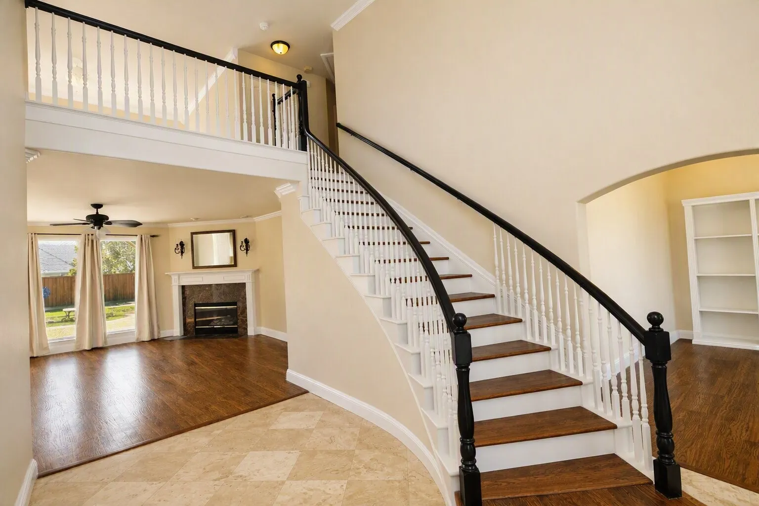 Grand staircase with dark hardwood treads and white balusters