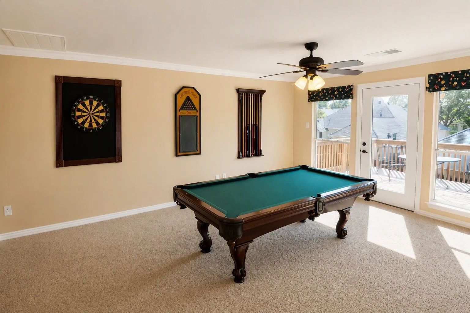 Carpeted room with a ceiling fan, crown molding, and direct access to an exterior wooden deck