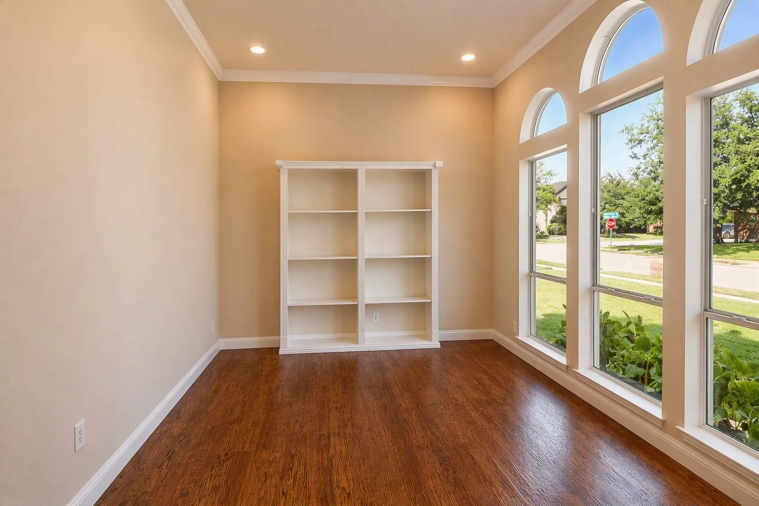 Hardwood flooring, recessed lighting, and a built-in shelving unit