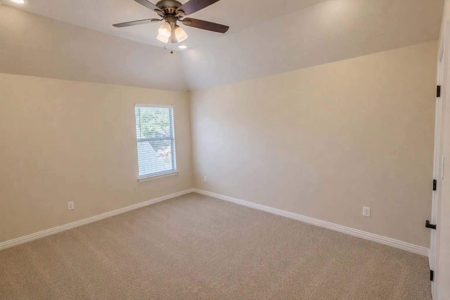 Vaulted ceiling, recessed lighting, ceiling fan with light fixture, carpeted flooring, and a single window with blinds