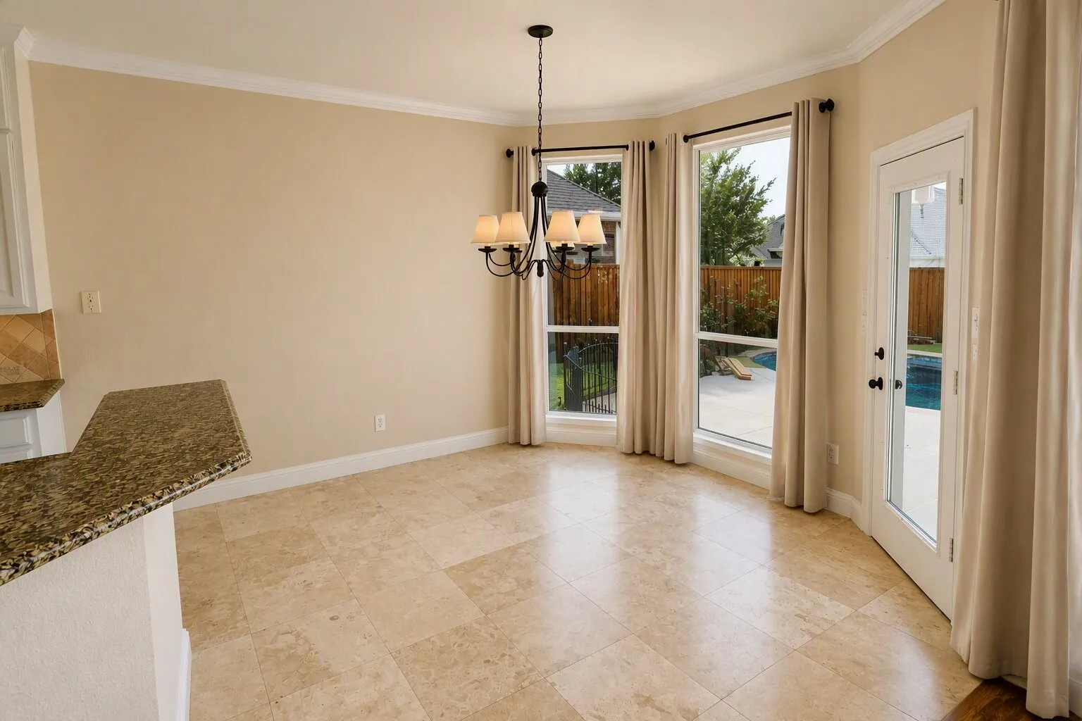 Crown molding, chandelier lighting, and a breakfast bar with granite countertop