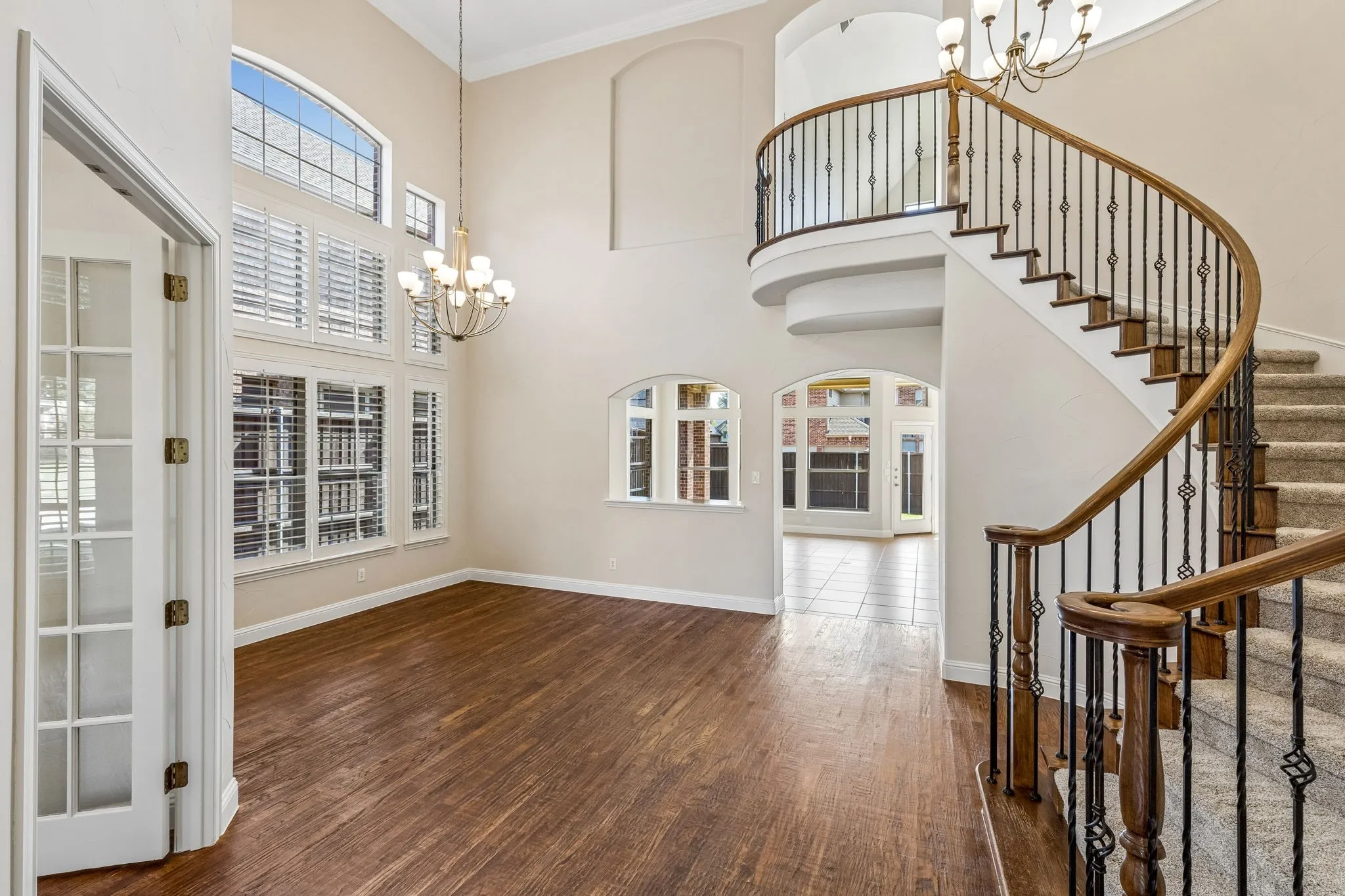 Two story foyer with grand staircase leading to dining room and office
