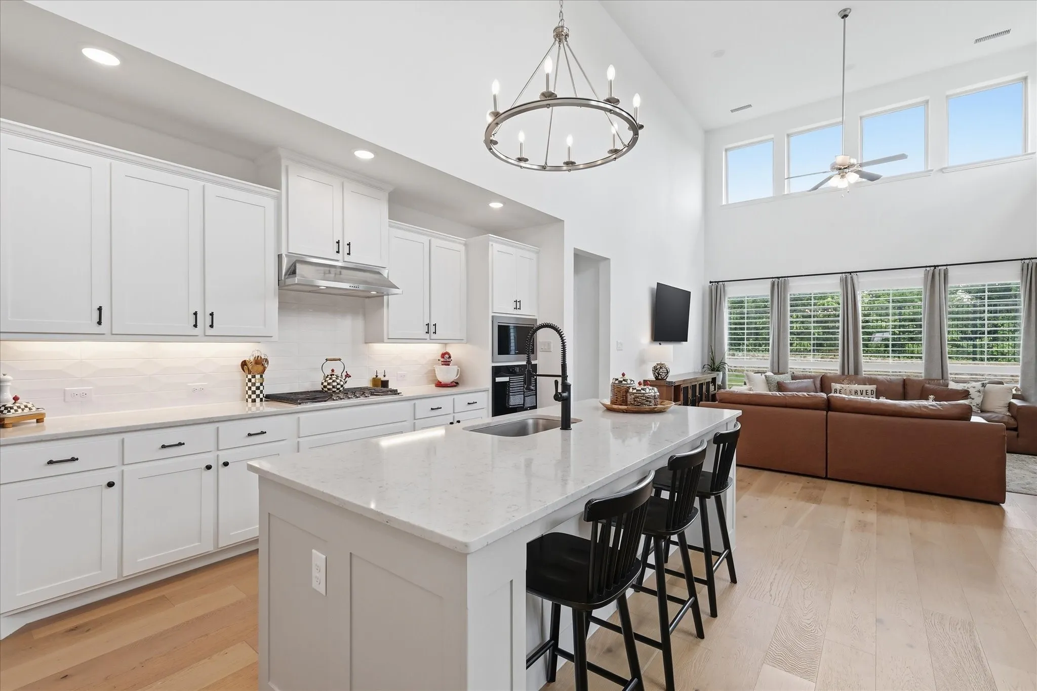 Open-concept kitchen and living area featuring a vaulted ceiling and wood-finish flooring