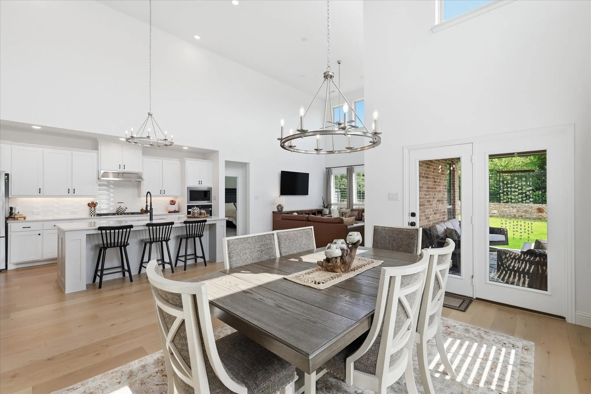 Bright open-concept dining area with vaulted ceilings and wood-finish flooring