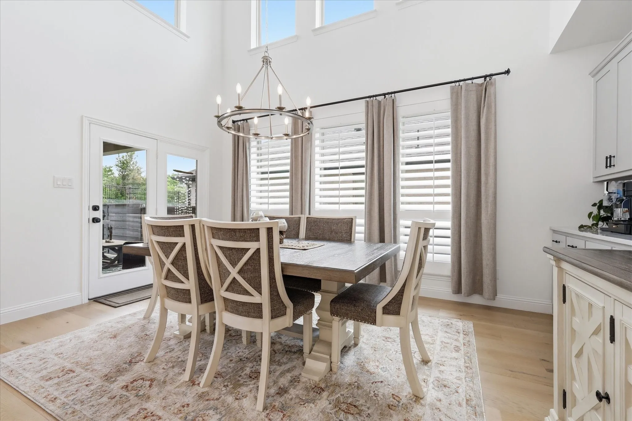 Dining area featuring a vaulted ceiling with clerestory windows, wood-finish flooring, and a chandelier