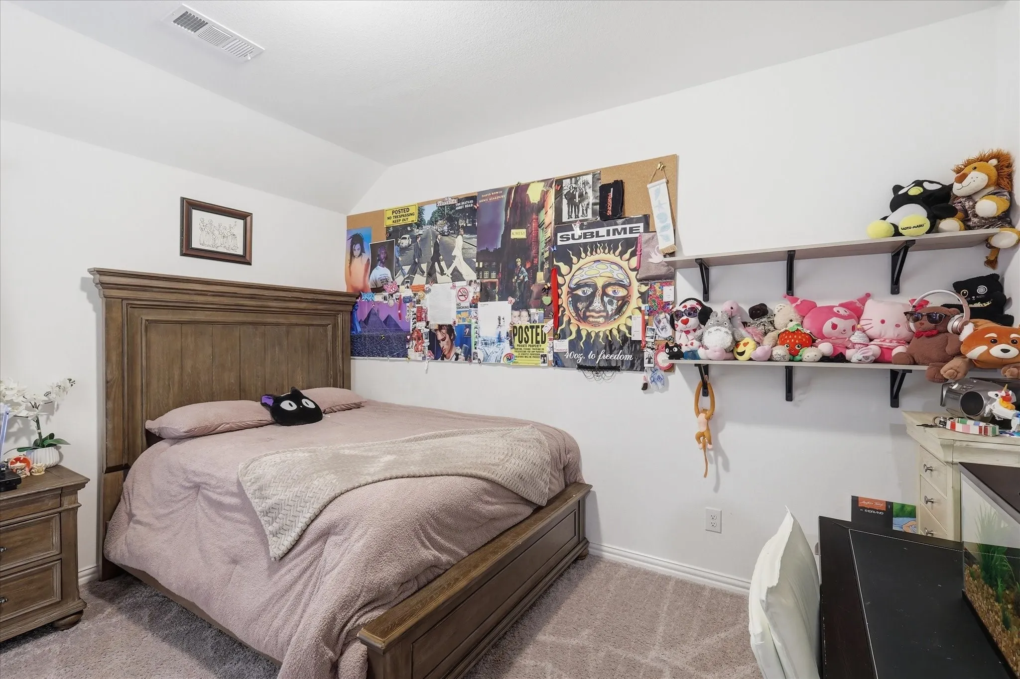 Carpeted room with a textured wood bed frame and matching nightstand