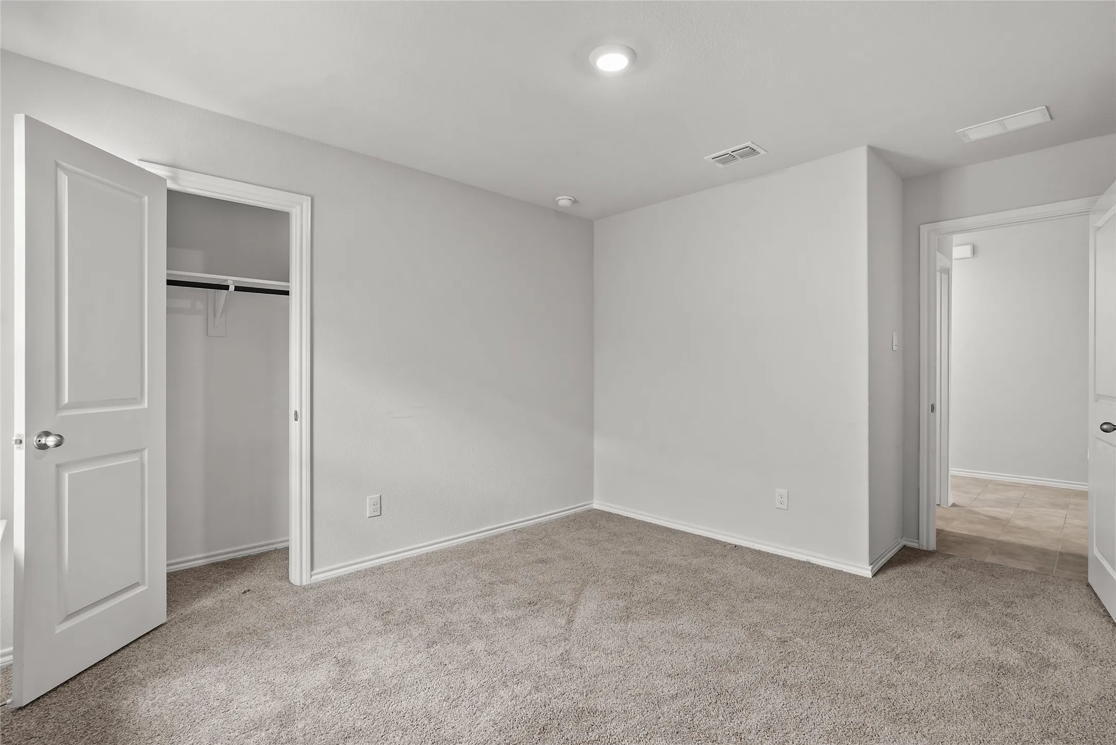 Carpeted room featuring a built-in closet with shelving and hanging rod, recessed ceiling lighting, and base molding