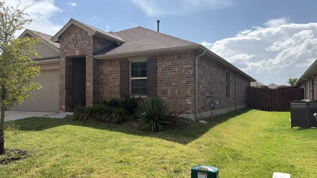 Brick exterior residence featuring a front entry, single-car garage, and established landscaping