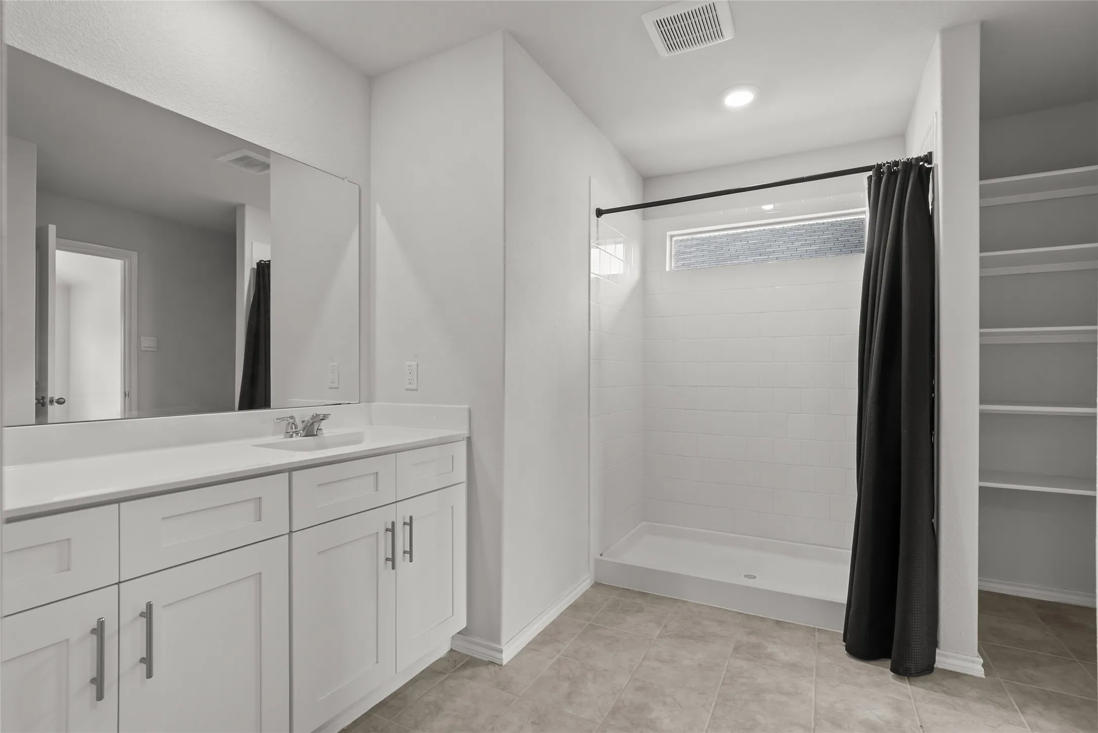 Bathroom featuring a white vanity with integrated sink, coordinating countertop, and a large wall mirror