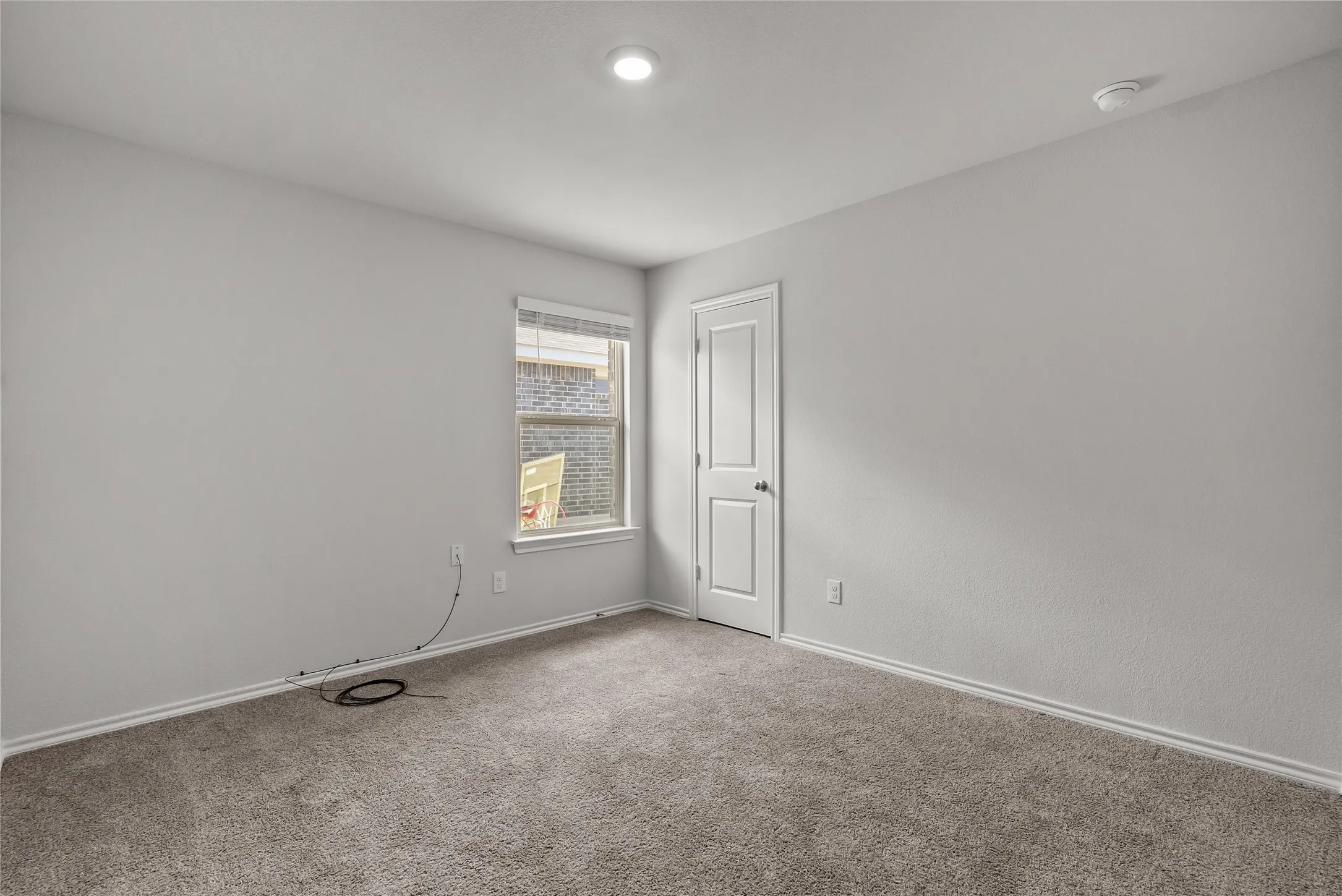 Spacious room featuring neutral carpeting and light gray wall paint