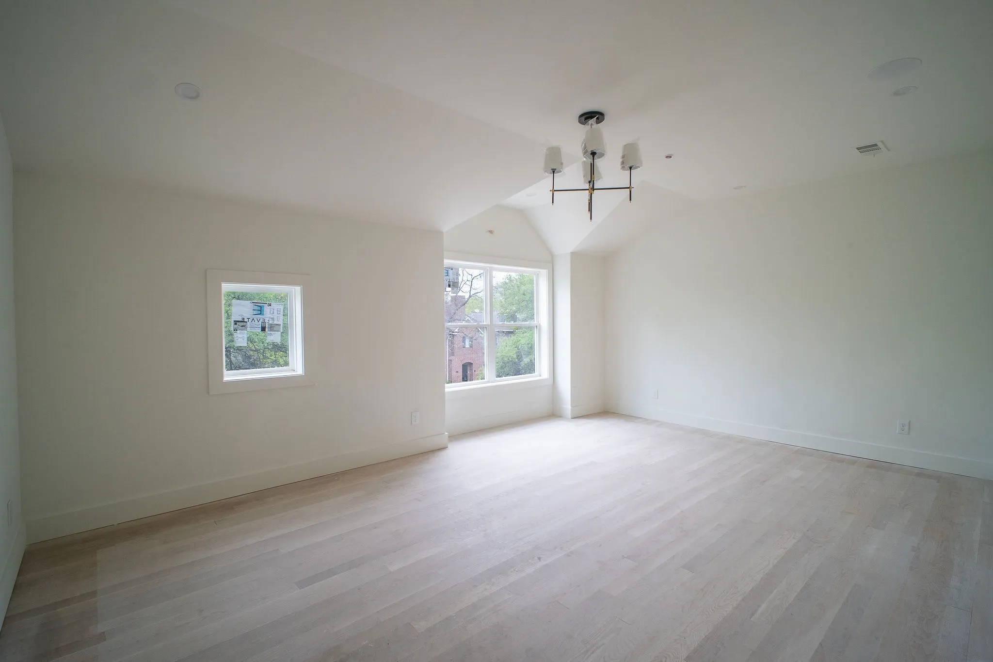 This expansive room features light-toned hardwood flooring and crisp white walls