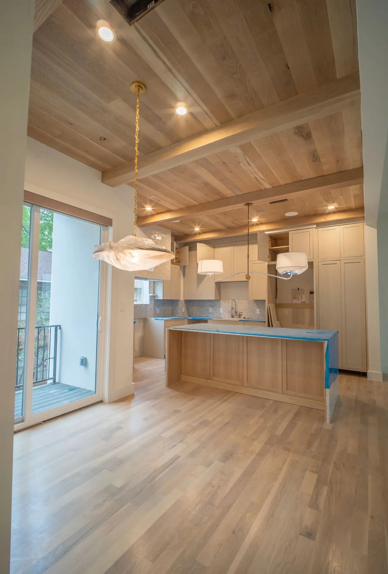 The property features hardwood floors, a wood plank ceiling with exposed beams, recessed lighting, and a kitchen island