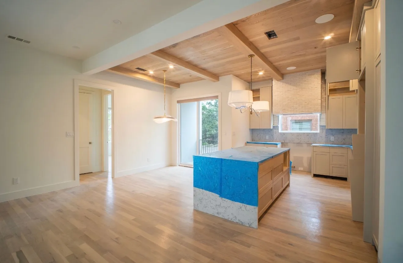 The kitchen features light-colored cabinetry, a tiled backsplash, and a central island with a light-colored countertop