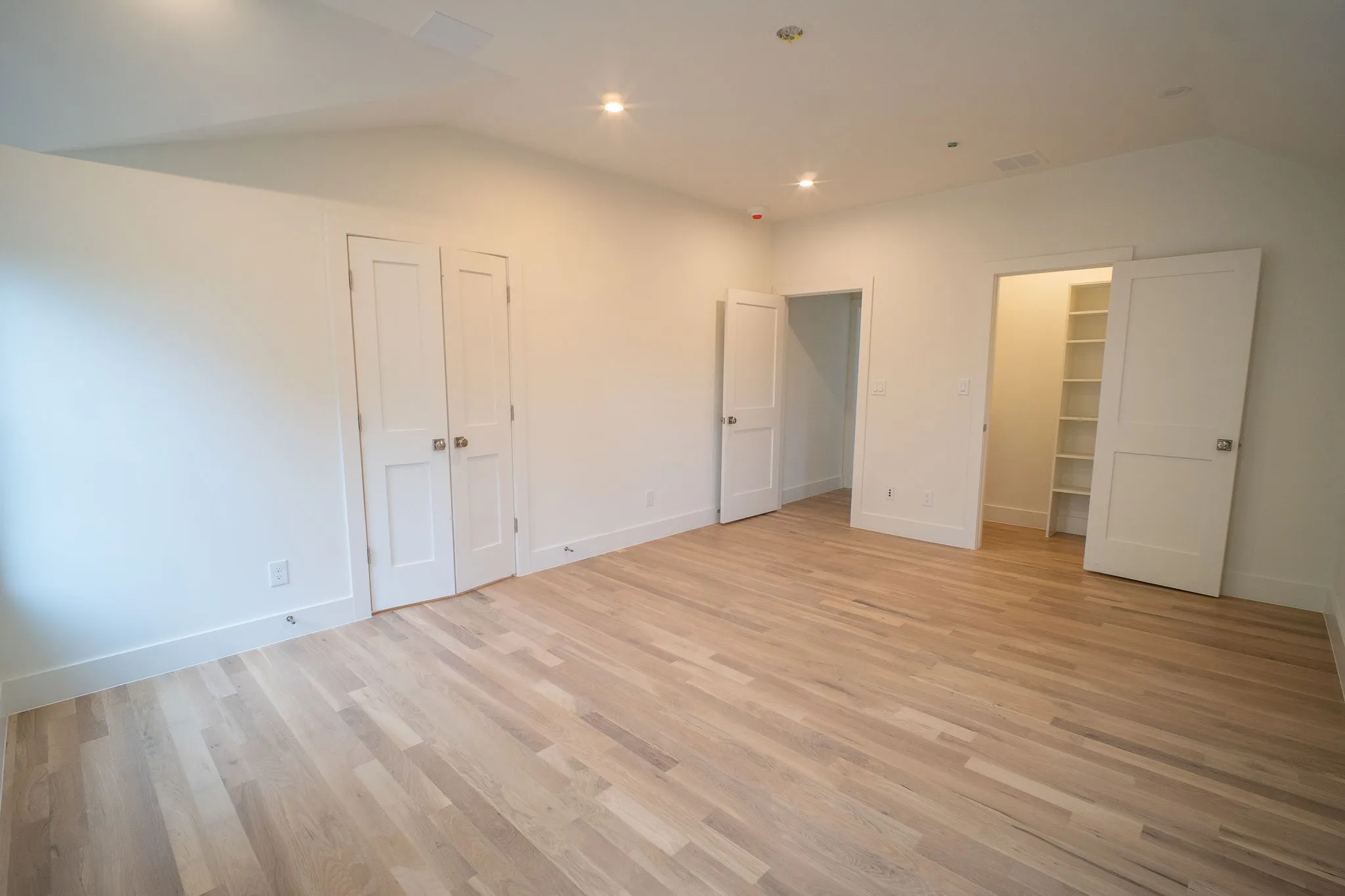 Bright room with light hardwood floors, white walls, and recessed lighting