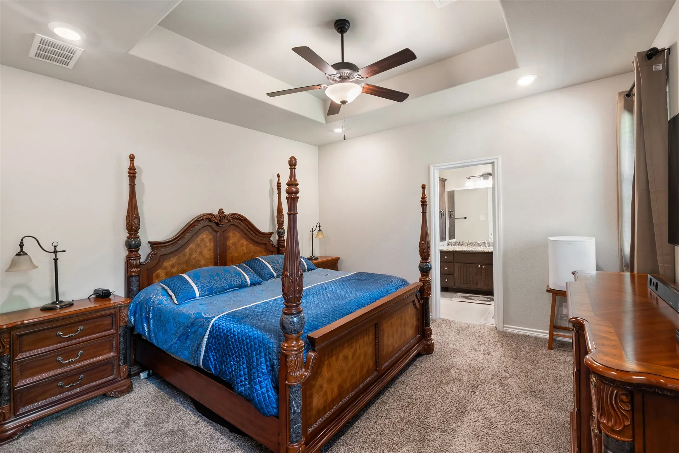 Carpeted room with a tray ceiling and recessed lighting