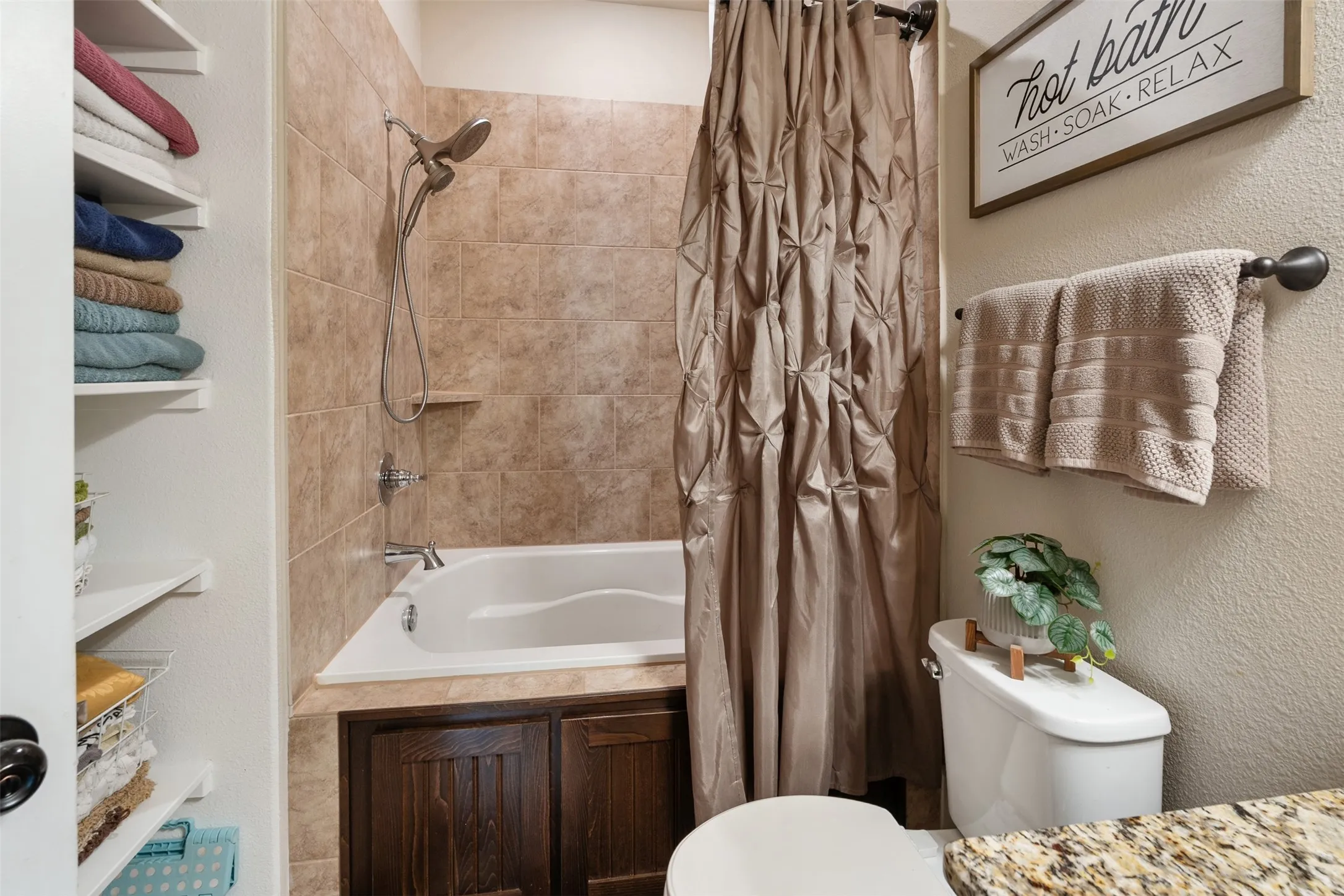 Full-size soaking tub with tiled surround and integrated shower head