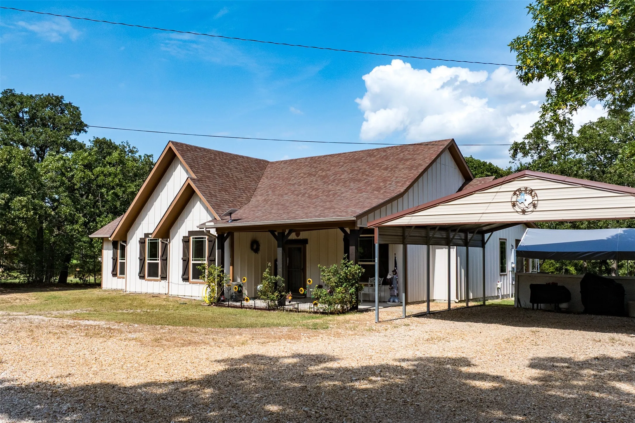 Exterior featuring a gabled roof, light-colored vertical siding, and dark shutters