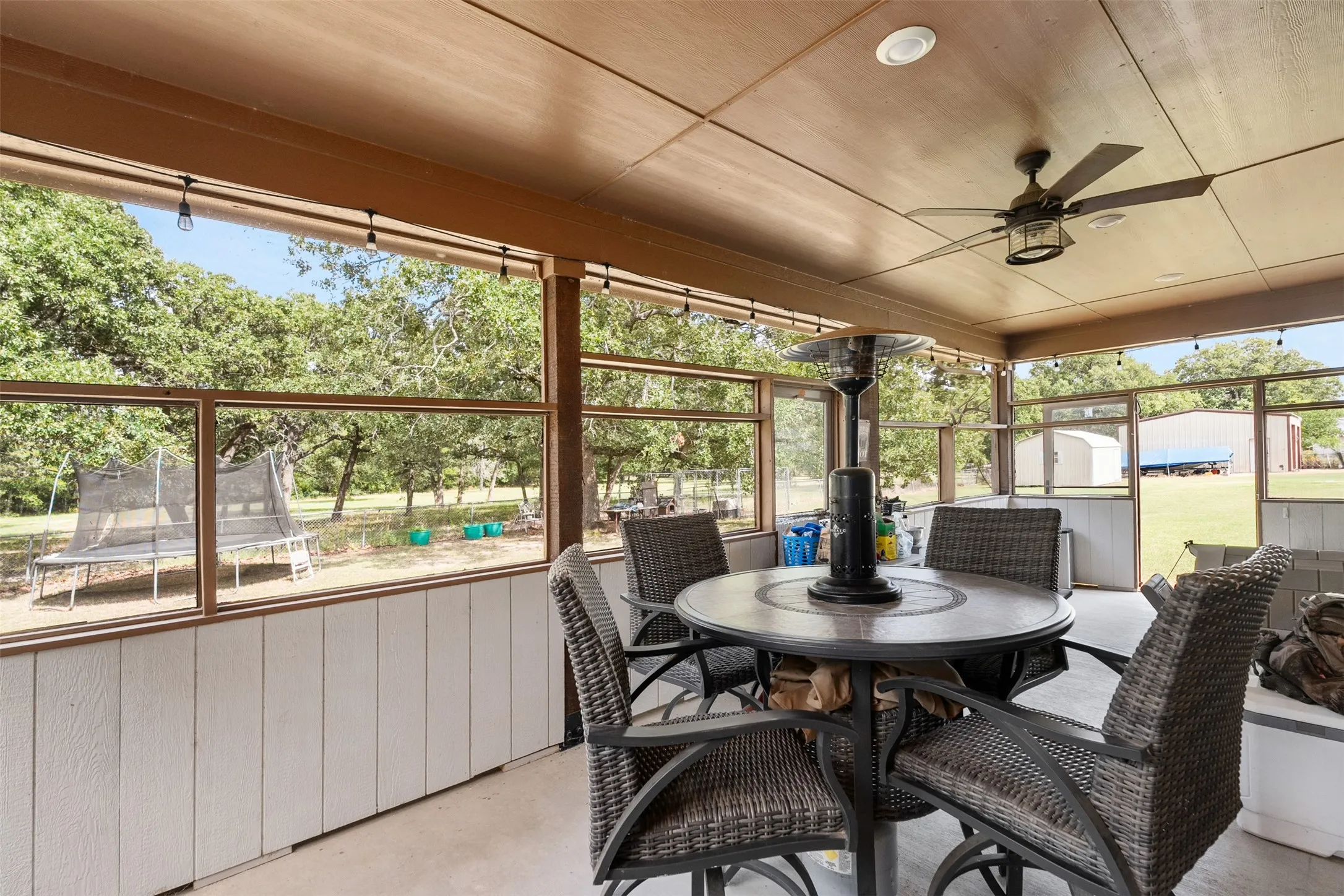 Screened-in patio with a wood-finish ceiling, ceiling fan, recessed lighting, and string lighting fixtures