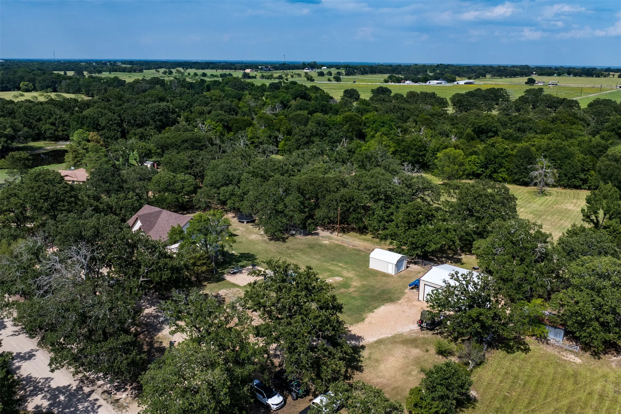 Expansive wooded property with a main residence and multiple outbuildings