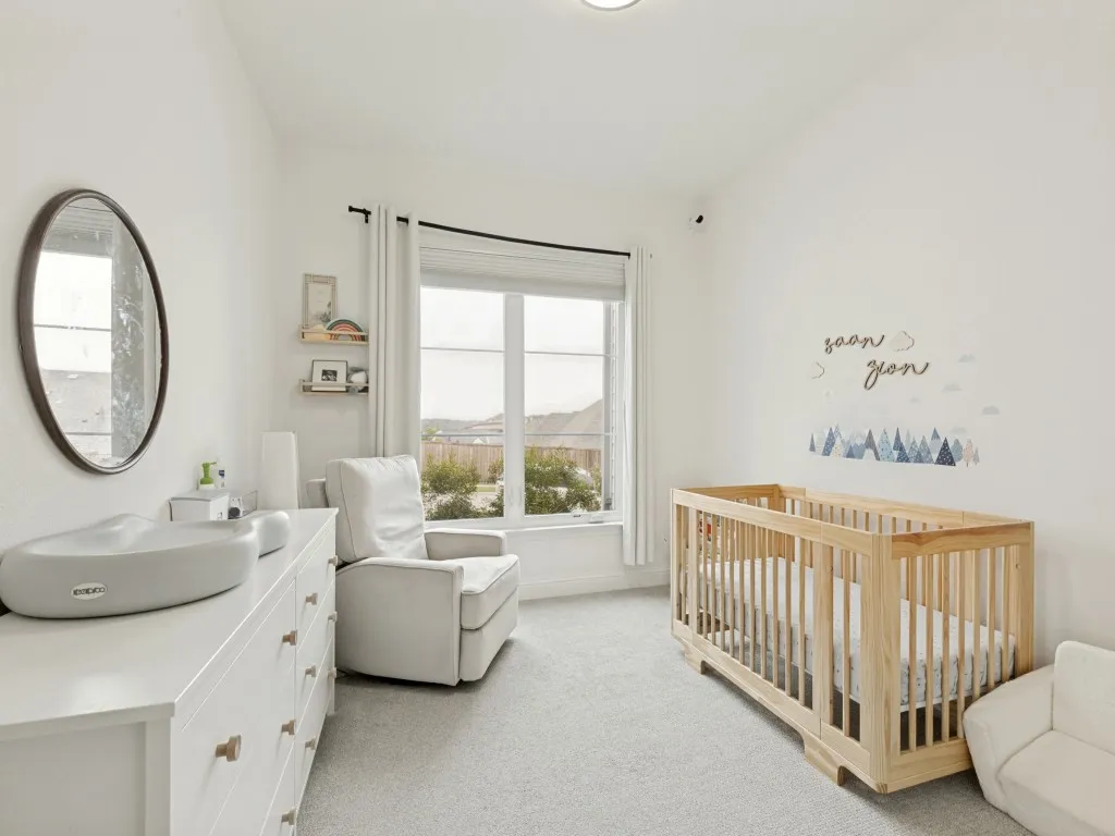 Bright room featuring light gray carpet, white walls, and a large window with white trim