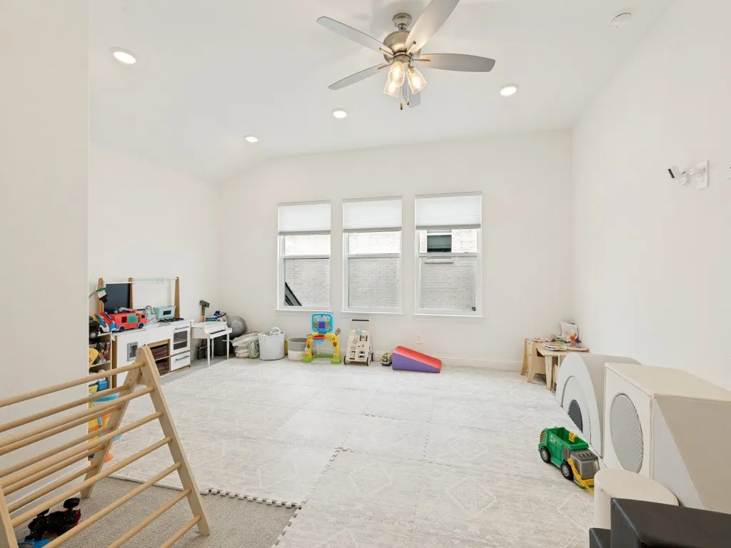 Spacious room featuring multiple windows with roller shades, recessed lighting, and a ceiling fan