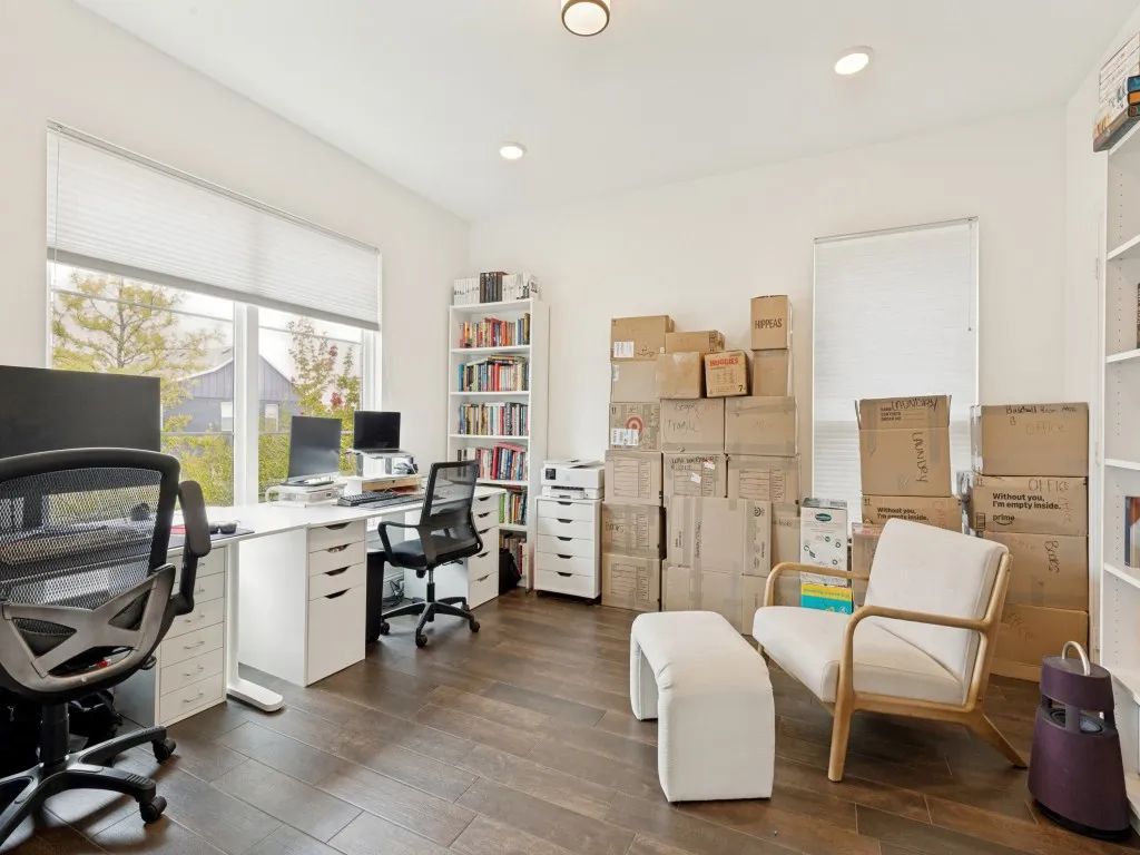 Spacious room featuring wood-finish flooring, white walls, and recessed lighting