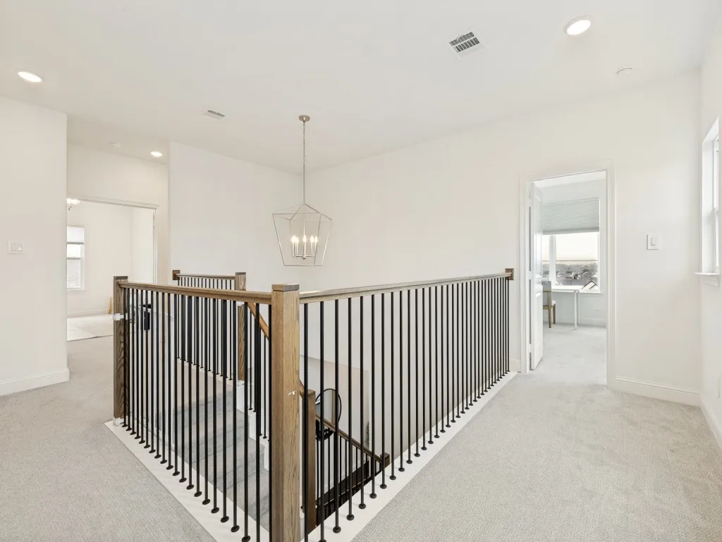 Upper landing with light-toned carpeting and recessed lighting