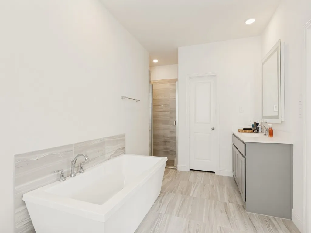 Freestanding soaking tub with chrome fixtures and a tiled surround