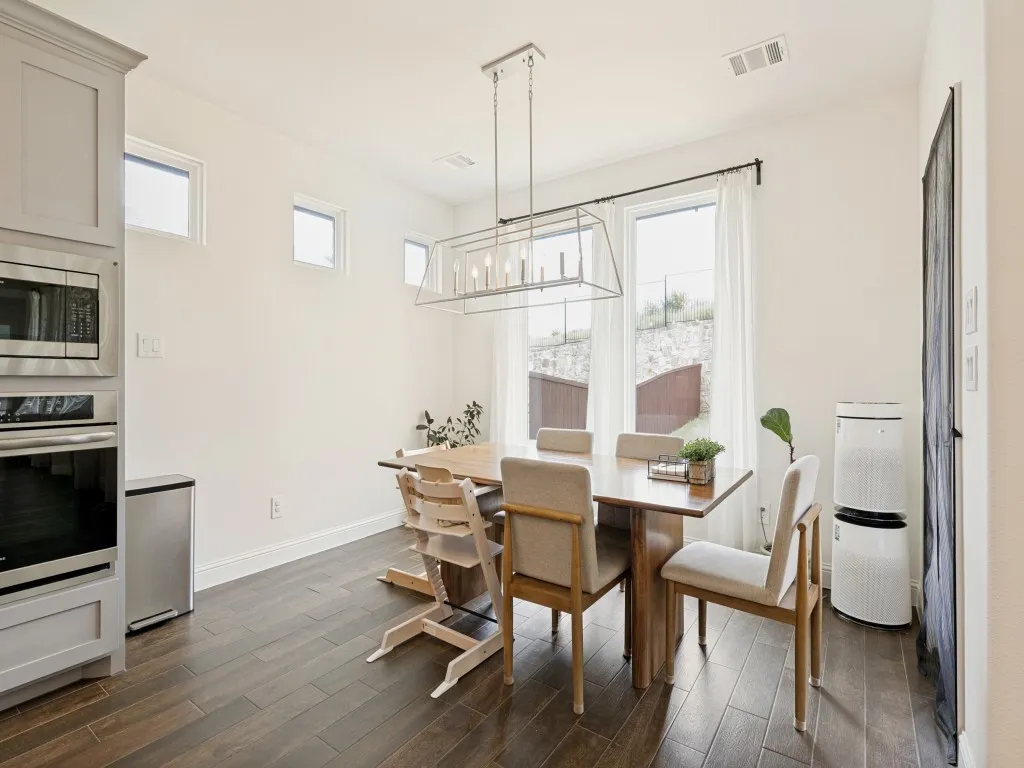 Dining area featuring wood-finish flooring and a contemporary chandelier