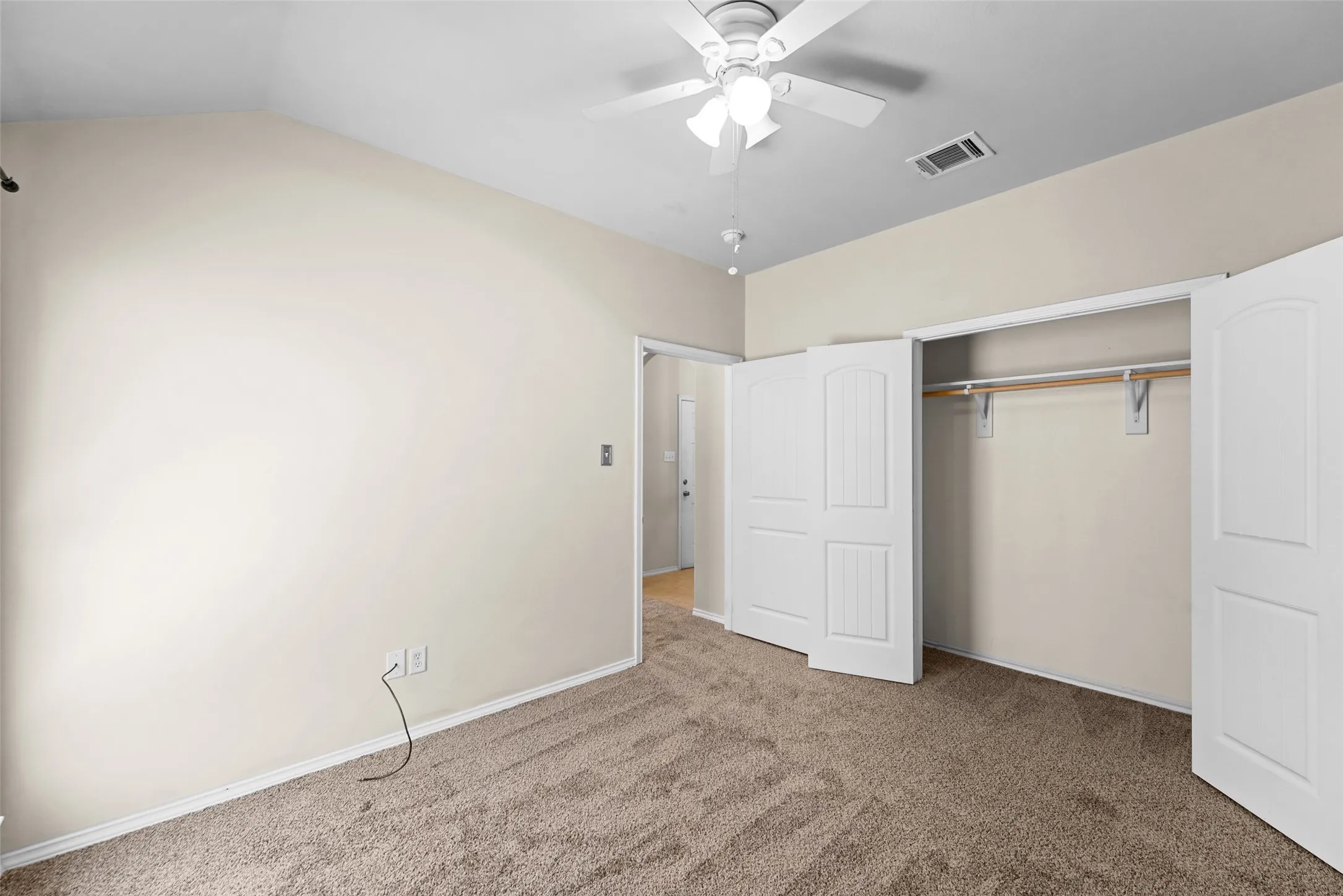 Carpeted room featuring a ceiling fan, vaulted ceiling, and white trim