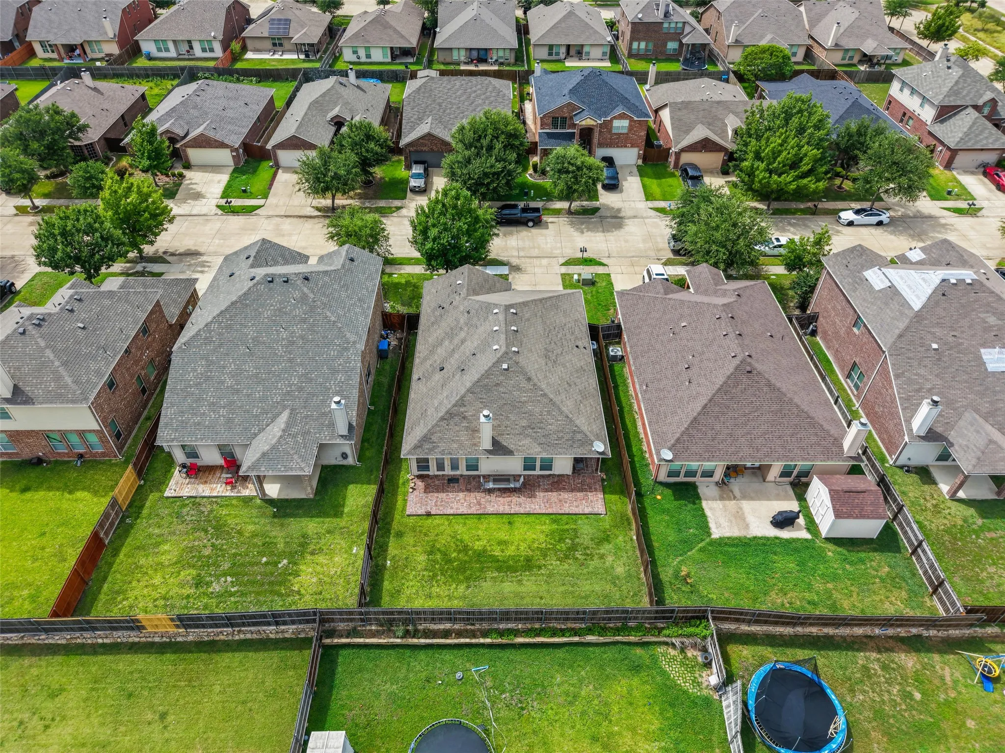 Expansive backyard featuring a manicured lawn, established fencing, and a concrete patio
