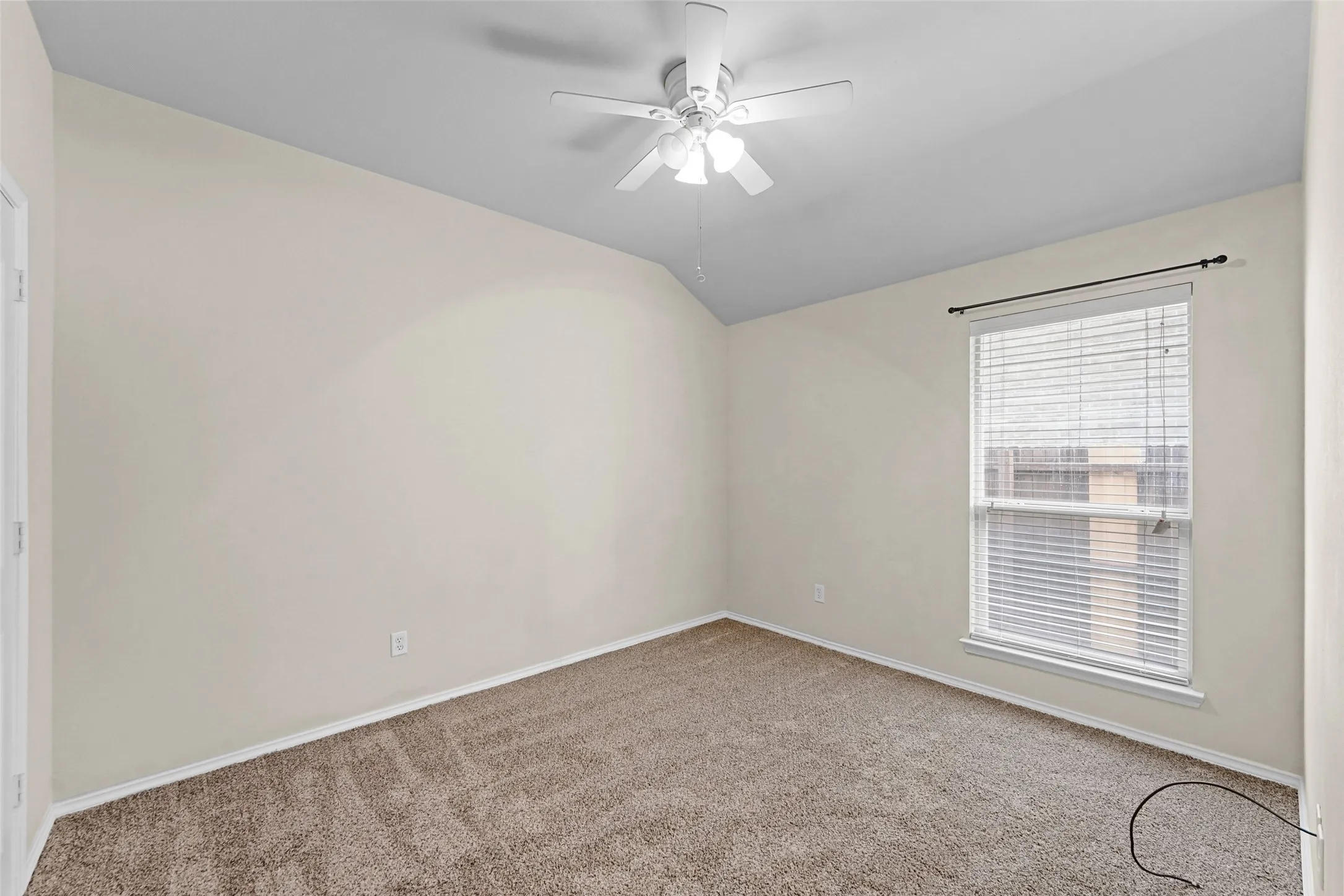 Room featuring neutral-toned walls, textured carpeting, and white trim