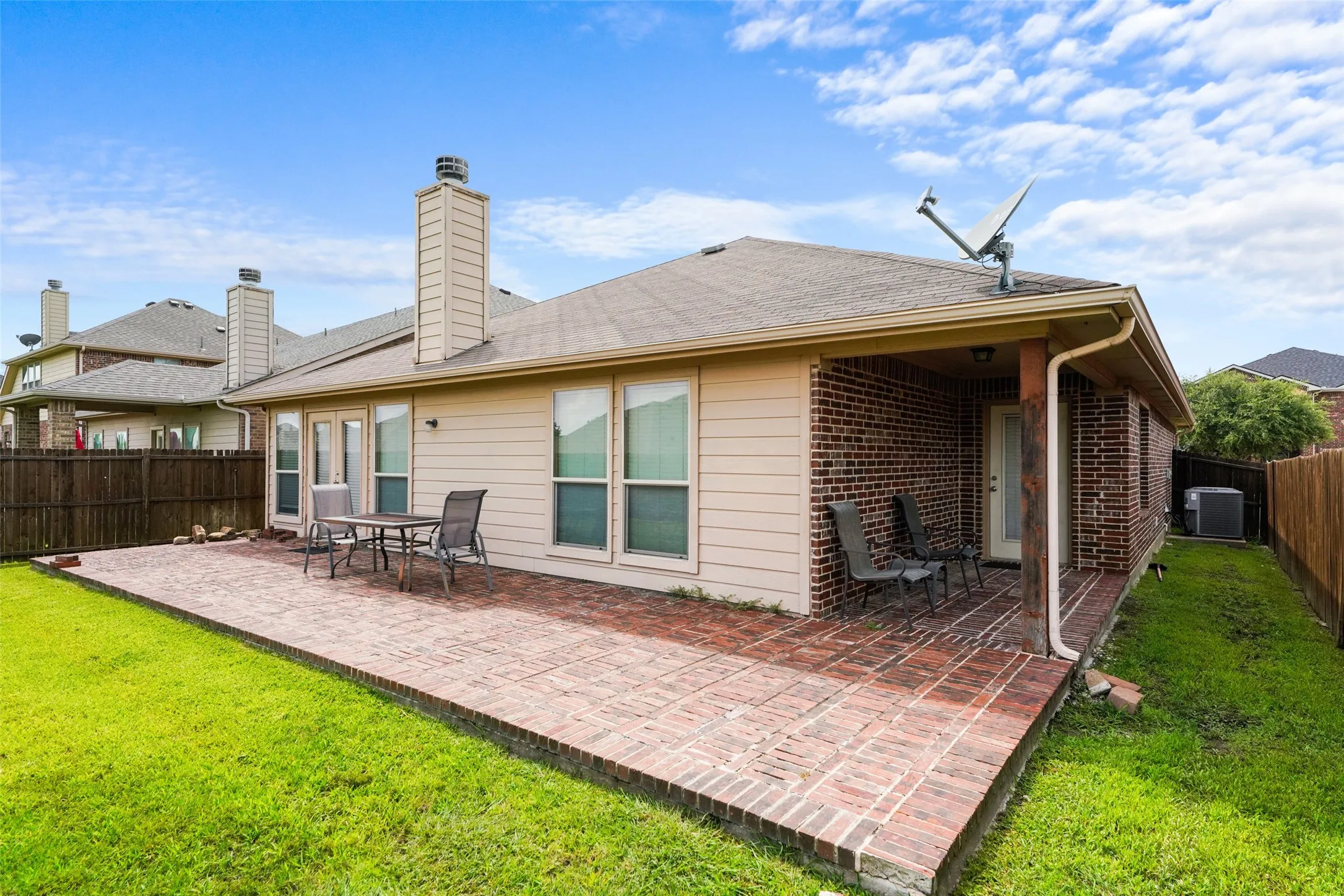 Expansive brick patio and covered porch area providing outdoor living space
