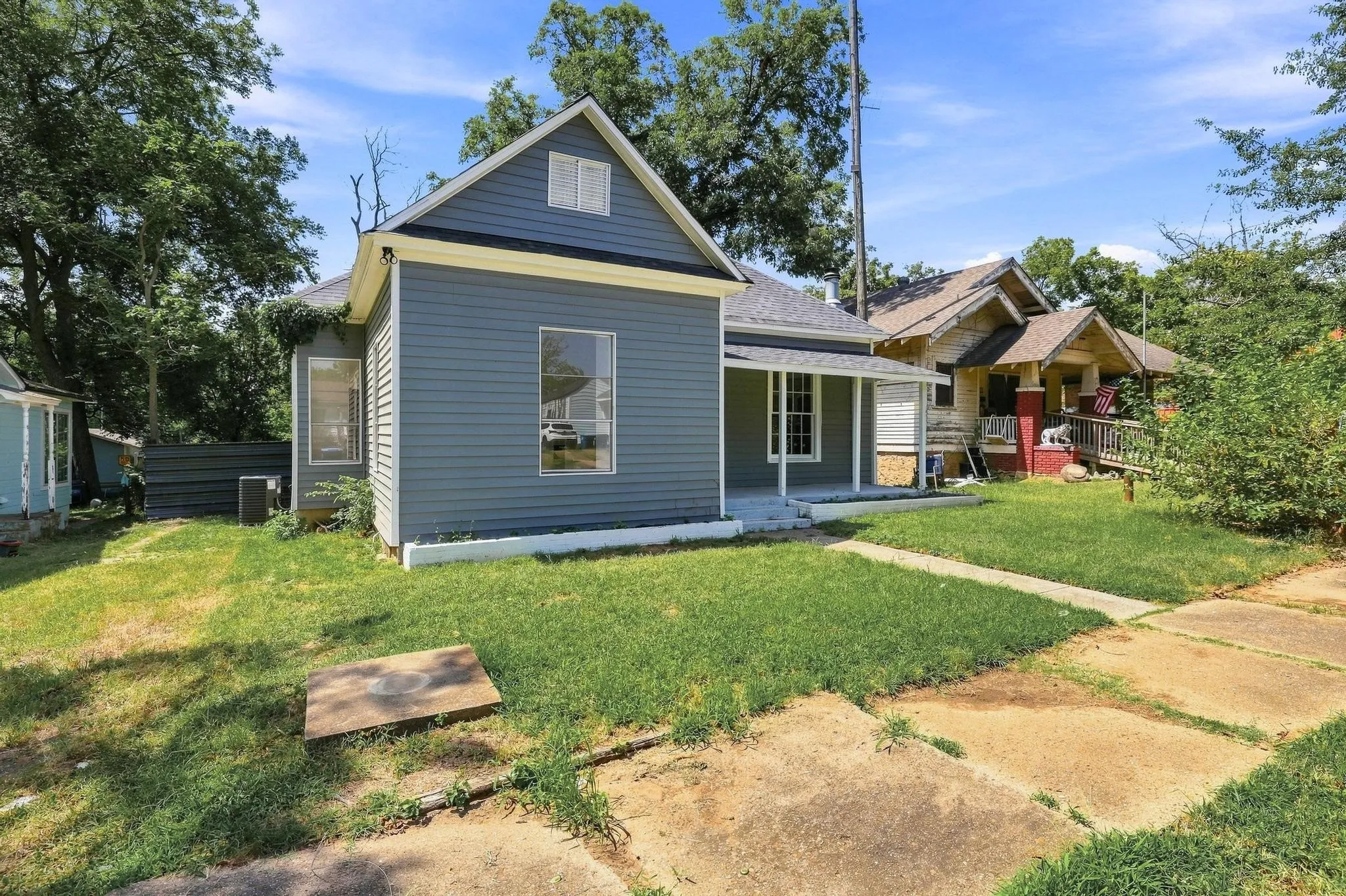 Charming exterior featuring gray siding, white trim, and a covered front porch with white columns